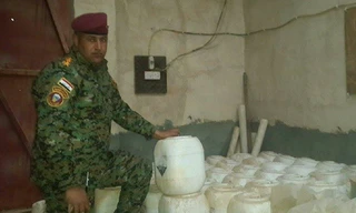 Binh sỹ Iraq bên cạnh những thùng trắng chứa vũ khí hóa học của IS