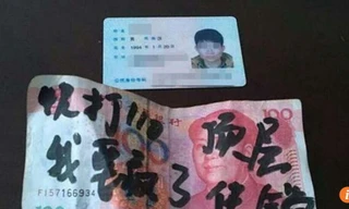 Tấm thẻ căn cước bọc trong tờ tiền mệnh giá 100 có viết lời cầu cứu 