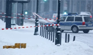 Xe cảnh sát bên ngoài văn phòng Thủ tướng Đức. Bốn bưu kiện màu vàng nằm bên ngoài tòa nhà.