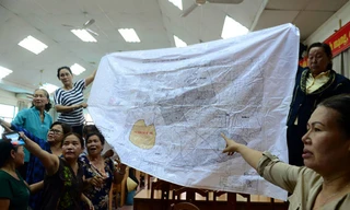 Trước khi buổi tiếp xúc cử tri diễn ra, một số người dân mang theo bản đồ quy hoạch 1/2.000 của khu đô thị mới Thủ Thiêm trưng trước hội trường. Ảnh: Zing 