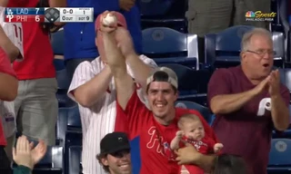 CĐV gây sốc khi vừa ôm con nhỏ vừa bắt bóng trên khán đài