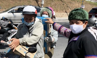 Ông Đoàn Ngọc Hải (bên phải) nhận các thùng sữa để chuyển lên vùng cao.