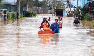 Dùng phao giúp phụ nữ chạy lũ