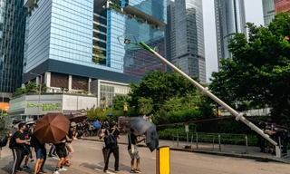 Người biểu tình kéo đổ cột đèn thông minh hồi tháng 8. Ảnh: Getty Images.