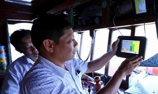 Cán bộ ngành thủy sản kiểm tra thiết bị giám sát hành trình khai thác trên tàu cá trước khi ra khơi, tại cảng cá Quy Nhơn, thành phố Quy Nhơn, tỉnh Bình Định. Ảnh: TTXVN