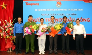 Tổng biên tập báo Tiền Phong Lê Xuân Sơn (bên phải) và Quyền Trưởng ban Tuyên giáo Trung ương Đoàn Lê Quang Tự Do (bên trái) tặng hoa các vị khách mời. Ảnh: Xuân Tùng