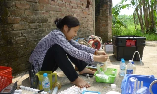 Một nghiên cứu viên (Đại học Quốc gia Hà Nội) đang lấy mẫu kiểm tra nước ngầm nhiễm arsenic tại Xã Vạn Phúc. (Ảnh do thành viên đoàn nghiên cứu cung cấp).