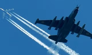 Máy bay SU-25 của Không quân Ukraine bay dưới một chiếc máy bay chở khách tại một cuộc diễn tập quân sự. (Nguồn: AFP) 
