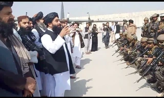 Phát ngôn viên Taliban Zabihullah phát biểu trước một nhóm tay súng tại sân bay Kabul ngày 31/8 Ảnh: Al Jazeera 