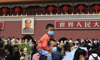 Một bé trai ngồi trên cổ bố khi đi chơi ở quảng trường Thiên An Môn ngày 3/5. Ảnh: AP 