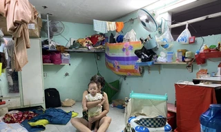 Mẹ vợ và con anh Nguyễn Văn Tuấn trong căn phòng trọ ở quận 11. Ảnh: DUY QUANG 