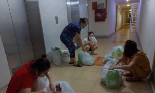 Người dân chung cư 12T2 (Nại Hiên Đông, Sơn Trà, Đà Nẵng) nhận hàng đặt mua từ tổ COVID-19 cộng đồng. Ảnh: Nguyễn Thành.