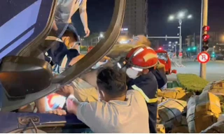 Giải cứu nam tài xế khỏi cabin xe tải bị lật ở khu vực cầu Rồng. Ảnh: Q.V