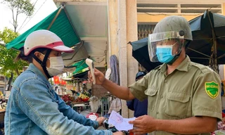 Người dân trước khi vào chợ đều phải xuất trình phiếu và được đo thân nhiệt. Ảnh: Nguyễn Ngọc