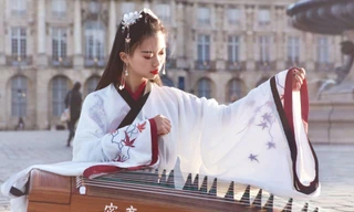 Cô gái mặc cổ phục gảy đàn trên đường phố