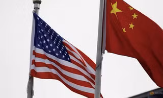 Quốc kỳ của Mỹ và Trung Quốc bên ngoài một công ty ở Bắc Kinh. (Ảnh: Reuters)