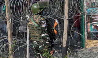 Một lính Ấn Độ đứng gác gần hàng rào dây thép gai ở Srinagar ngày 12/10. (Ảnh: AP)