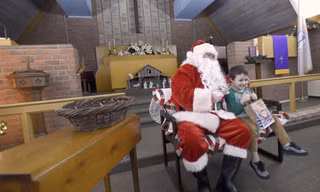 Một bé trai nhận được quà tặng Giáng sinh từ chương trình tình nguyện của Angel Tree. (Ảnh: AP)