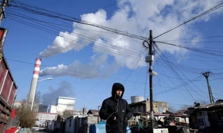 Một người đàn ông đang đi gần nhà máy điện than ở Cáp Nhĩ Tân, tỉnh Hắc Long Giang, Trung Quốc. (Ảnh: Reuters)