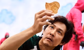 Nam chính tham gia trò chơi tách kẹo trong phim "Trò chơi con mực". (Ảnh: Netflix)