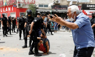 Một người đàn ông phản ứng khi cảnh sát bắt một người biểu tình ở Tunis ngày 25/7. (Ảnh: Reuters)
