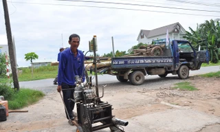 Ông Nguyễn Thanh Tâm đem đồ nghề vào nhà. Ảnh: Hòa Hội.