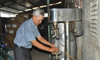 Ông Sáu Tia đang đóng nút chai bằng máy. Ảnh: Hòa Hội.