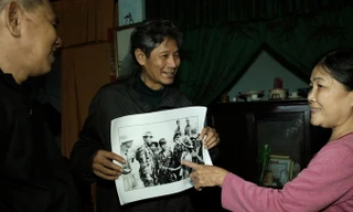 Tay bắt mặt mừng hôm nay: Bà Chiến chỉ vào mình trong ảnh chụp 45 năm trước. Người cầm ảnh là nhiếp ảnh gia Chu Chí Thành, còn lại là ông Nghĩa. Ảnh: CHU CHÍ THÀNH. (Trong ảnh, Bùi Trọng Nghĩa bắt tay o Chính còn Nguyễn Huy Tạo khoác vai Nghĩa. O Chiến đứ