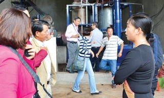 Chị Triệu Thị Châu (áo đen) trả lời câu hỏi của khách tham quan mô hình.