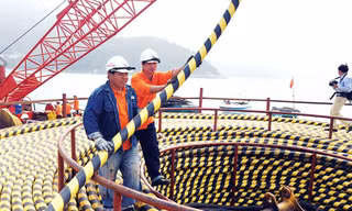 Công nhân thi công kéo cáp ngầm qua biển để cấp điện cho đảo Cù Lao Chàm.