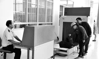 Hành khách cho hành lý đi qua máy soi chiếu của hải quan để kiểm tra​. Ảnh: Tuấn Nguyễn.