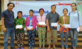 Nhà báo Lê Minh Toản và Hoa hậu Đỗ Mỹ Linh trao hỗ trợ của Quỹ Thiện Tâm tới đồng bào bị thiệt hại do mưa lũ.