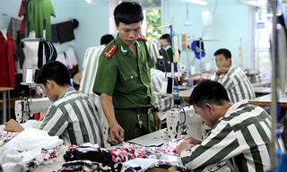 Hướng dẫn phạm nhân trong xưởng may. Ảnh: Xuân Tùng