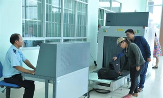 Hành khách cho hành lý đi qua máy soi chiếu của hải quan để kiểm tra. Ảnh: Tuấn Nguyễn.