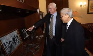 Thượng nghị sĩ Mỹ John McCain giới thiệu với Tổng Bí thư Nguyễn Phú Trọng một số ảnh tư liệu. Ảnh: TTXVN