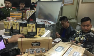 Đối tượng và tang vật một vụ buôn lậu thuốc lá ngoại số lượng lớn bị Công an Hà Nội bắt giữ.