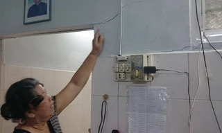 Cô giáo già chỉ vết nứt chi chít tường nhà.