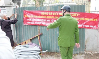 Cựu trọng tài bóng đá Dương Mạnh Hùng tháo gỡ băng-rôn theo yêu cầu của cơ quan chức năng. Ảnh: Thành Duy.