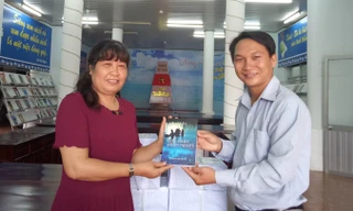 Nhà báo Trương Hòa Hội tặng sách cho bà Phan Thị Thùy Giang, Giám đốc Thư viện TP Cần Thơ.