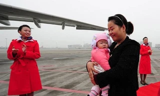 Cô Lou Wei bế con lên máy bay tham dự Đại hội Đảng Cộng sản Trung Quốc lần thứ 18 ở Bắc Kinh