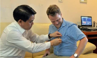 Chủ tịch Nguyễn Đức Chung gắn lên ngực áo anh James Joseph Kendall logo của thành phố Hà Nội.