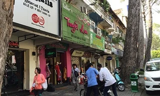 Một số cửa hàng trên đường Lê Lợi đặt biển hiệu/bảng quảng cáo có mép dưới bằng nhau (tức chiều cao tối đa 2m). Ảnh: Quỳnh Như/PLO