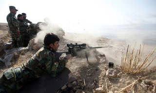 Một chiến binh người Kurd xả súng về phía IS tại thị trấn Naweran, gần Mosul vào ngày 23/10.