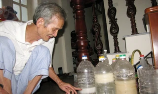 Ông Nguyễn Phúc Thanh bên cạnh các bình thí nghiệm làm bột giấy