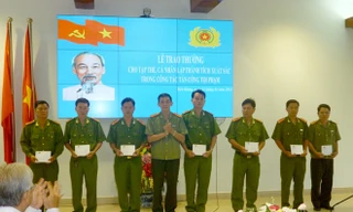 Đại tá Nguyễn Hữu Trí (thứ tư từ trái sang), Phó Giám đốc công an tỉnh Tiền Giang trao khen thưởng cho tập thể cán bộ có thành tích xuất sắc trong công tác tấn công tội phạm dịp Tết Nguyên đán 2014