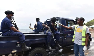 Nhân viên y tế đo thân nhiệt cho cảnh sát tại Congo. Ảnh: Reuters