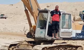 Abdullah Abdul-Gawad và chiếc máy xúc "tí hon". Ảnh: BI