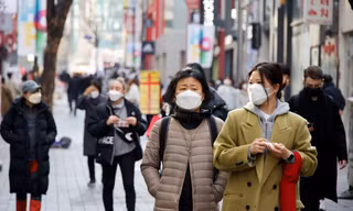 Người dân Seoul đeo khẩu trang đi dạo phố. Ảnh: Reuters