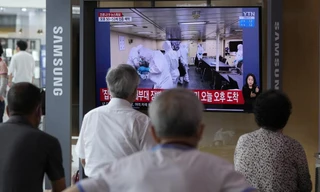 Người dân Hàn Quốc theo dõi thông tin về tàu khu trục Munmu The Great. Ảnh: AP