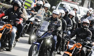 Ông Bolsonaro (lái xe, ở giữa) đội mũ bảo hiểm nhưng không đeo khẩu trang. Ảnh: AP